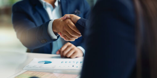 Business people, negotiation and handshake for deal, agreement or partnership in office. Shaking hands, closeup and hiring offer for recruitment, b2b collaboration or data analyst at table in meeting